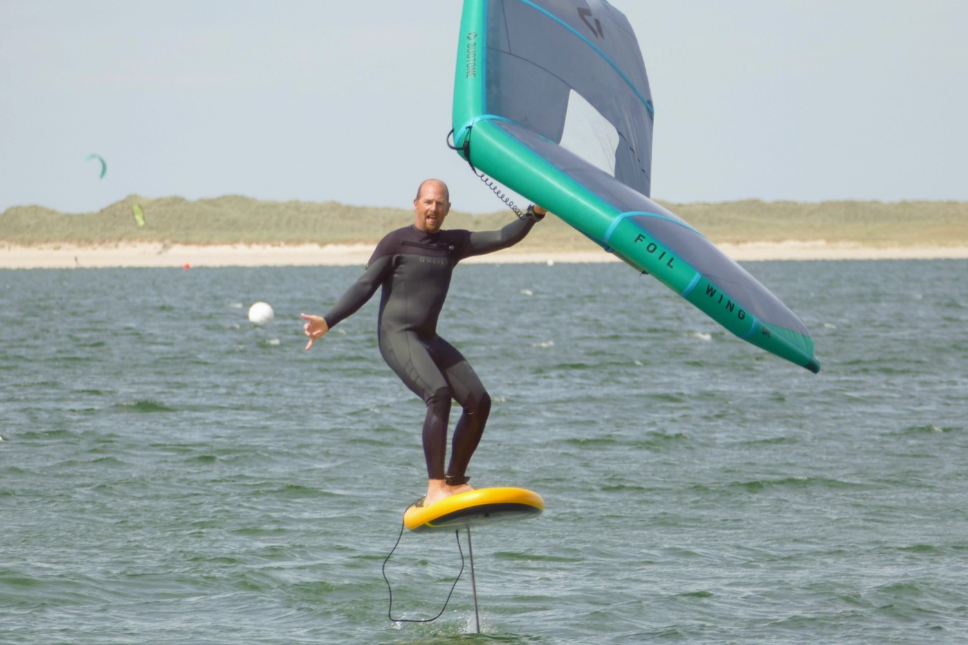 Rider en wingfoil, foil sorti de l'eau